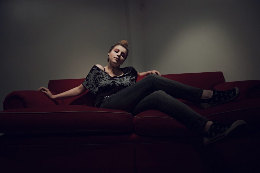Punk rock photoshoot with blonde chicago girl sitting cross legged on a couch