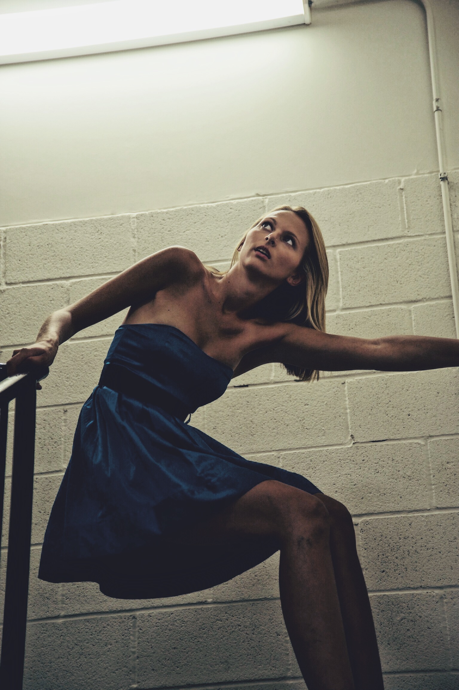 Model Olivia Banaszewski in a stairwell and blue dress from the photoshoot 'Desire' by Jason Kraynek