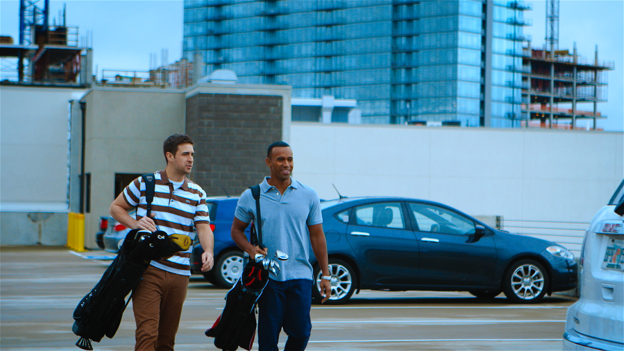 AVMA Life ad campaign actors walk with golf clubs through a upper parking garage shot by cinematographer Jason Kraynek