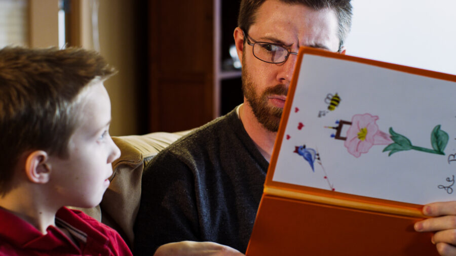 Father reading a book about the birds and bees to his son.