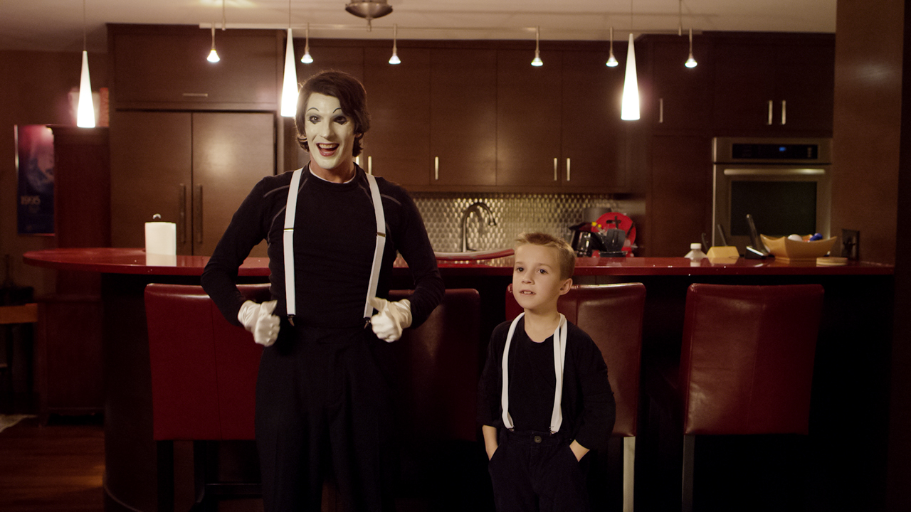 Father and son in mime outfits standing in a dining room.