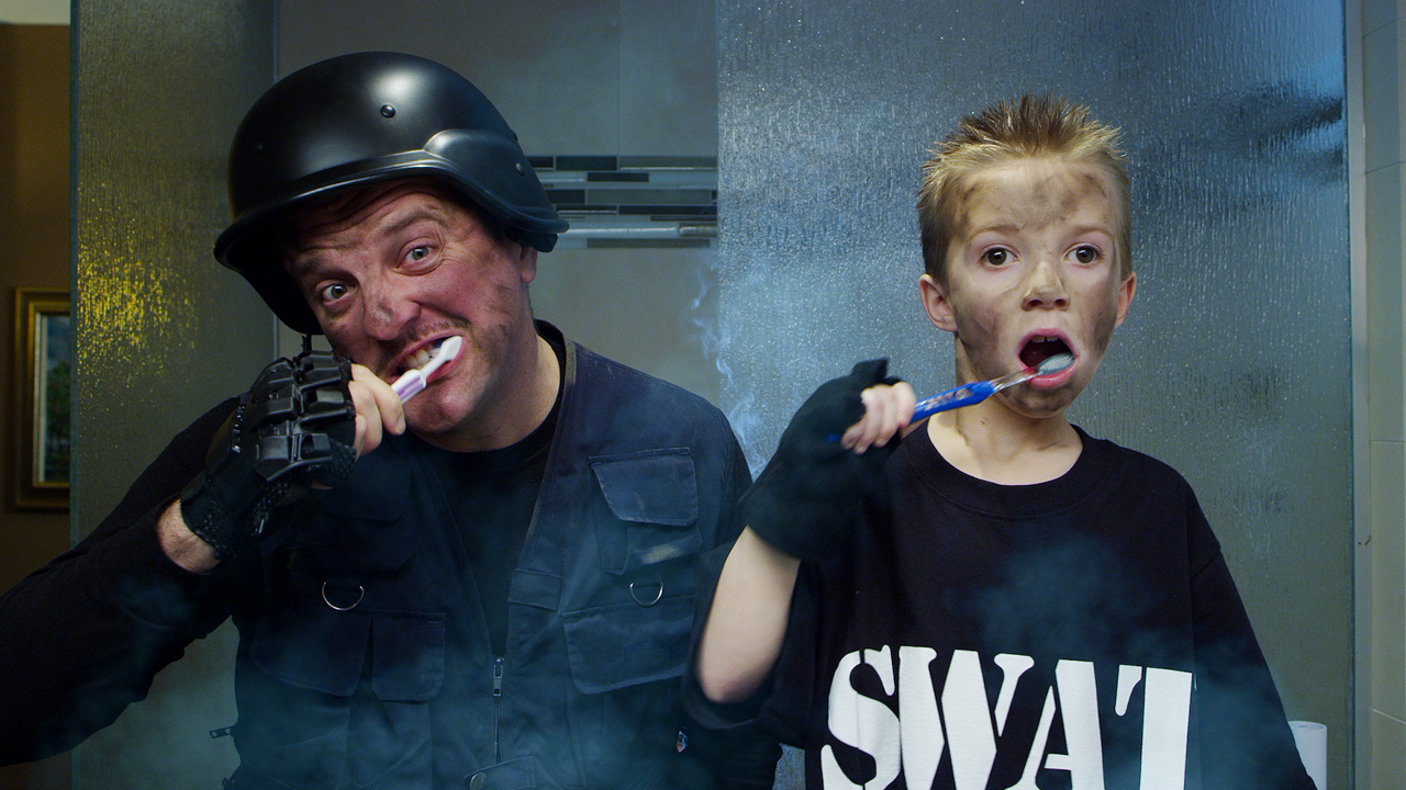 Father and Son brush teeth in a Bomb Squad outfit with smoke coming from their clothes.