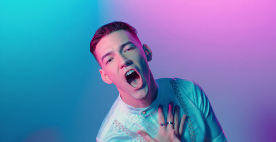 music artist 'Carson' in pink and blue lights with hand at face for 'Good Love' music video shot by cinematographer Jason Kraynek