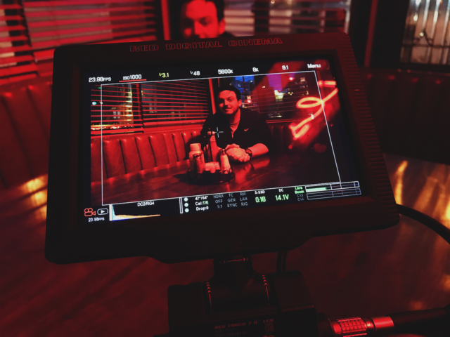 behind the scenes shot of man in red light at a restaurant booth in the short film 'the Handoff'