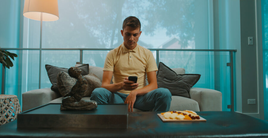 man on couch reads text messages from the web series "Queers!" shot by cinematographer Jason Kraynek