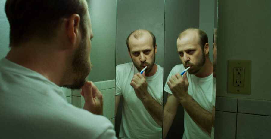 Music Video frame grab, Ganser - Psy Ops, man brushes teeth in multiple bathroom mirrors