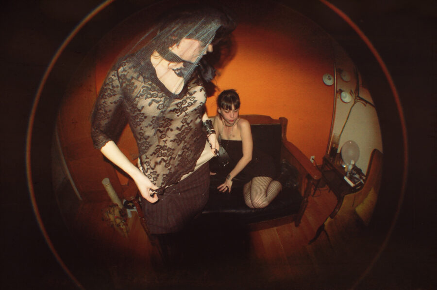 Fisheye lens with models wearing black lace in a living room.