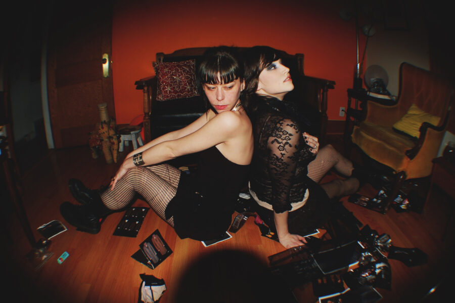 Models in black lace on a floor with fashion photos on the hardwood floor.