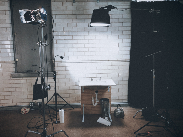 Behind the scenes on a commercial video set with lighting and cameras.