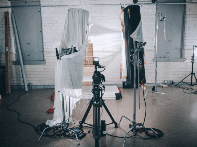 Behind the scenes on a commercial video set with lighting and cameras.