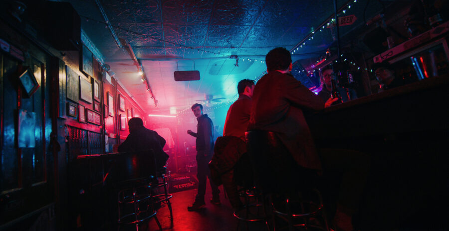 man stands in a colorful bar with a wide angle lens from the feature film 'FANG' shot by cinematographer Jason Kraynek