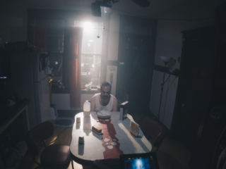 sad man sits in dark harsh lit kitchen w bowl of cereal in the short film 'the Handoff'