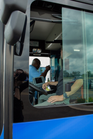 Reflection of the photographer shooting the window of a public bus.