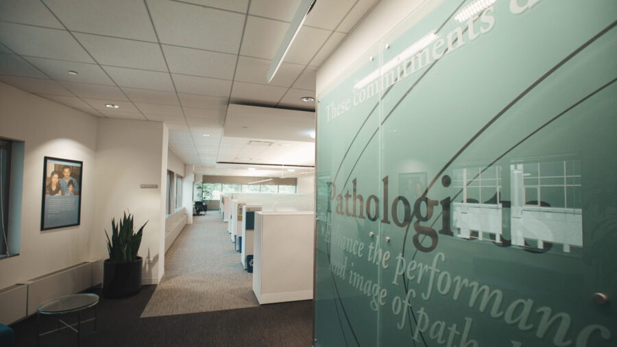 Interior of white office space with green glass images and slogans