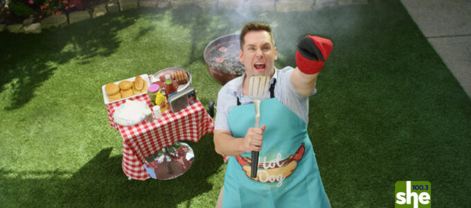 man in backyard grilling singing to the sky while holding up his glove