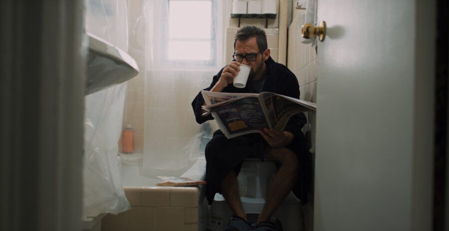 Actor in a advertisment campaign short film for Steel Supplements wakes up in the bathroom with coffee and the morning paper