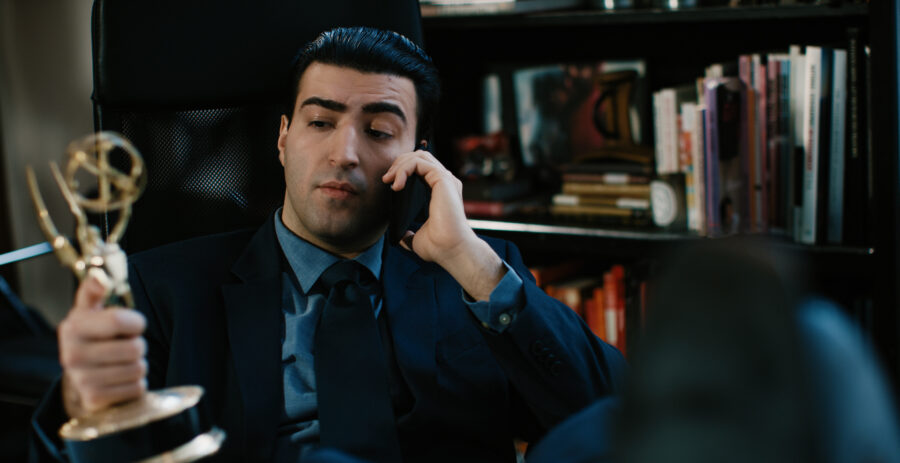 Actor in a advertisment campaign short film for Steel Supplements hold a Emmy on the phone