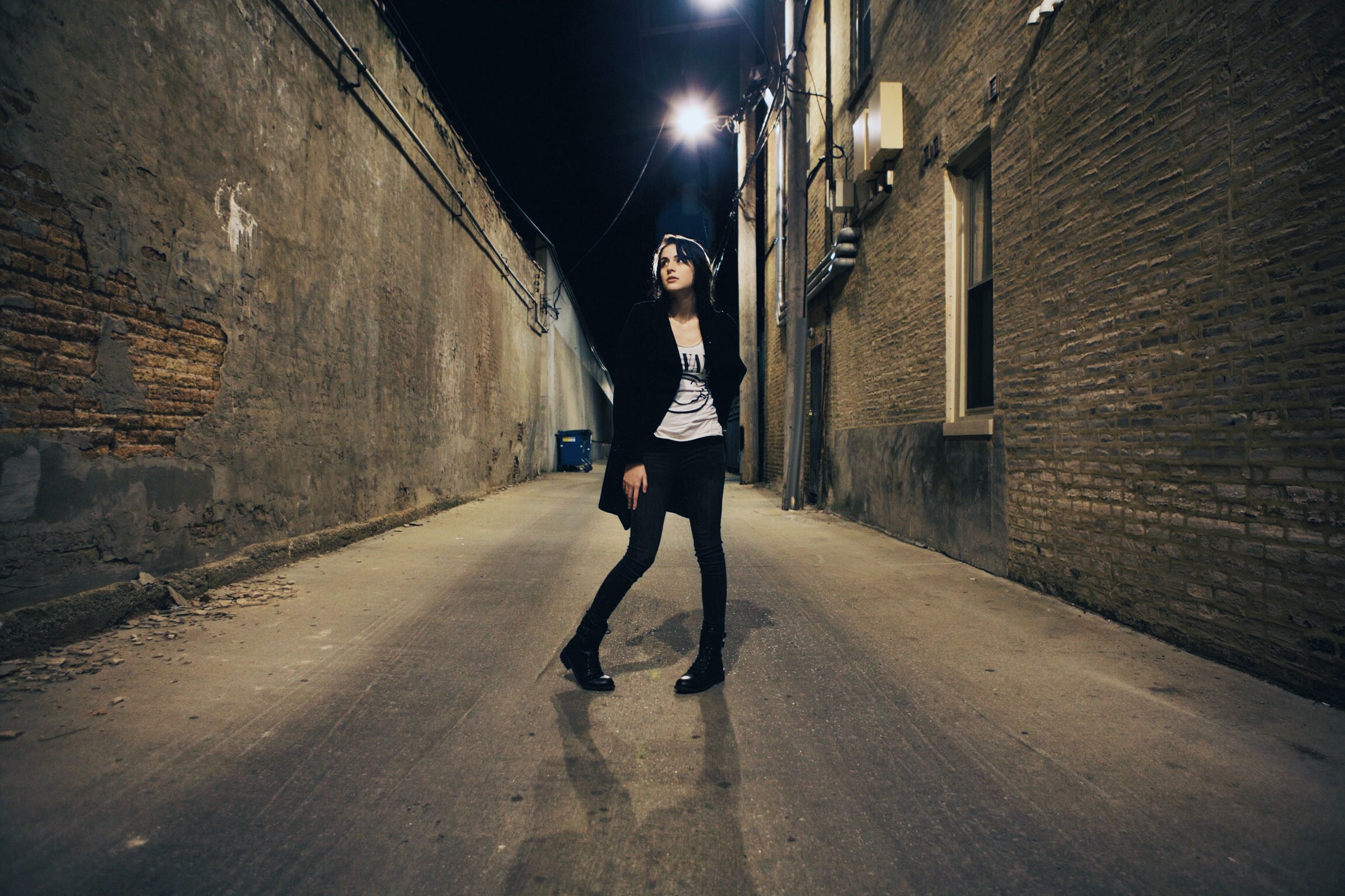 model in alleyway at night