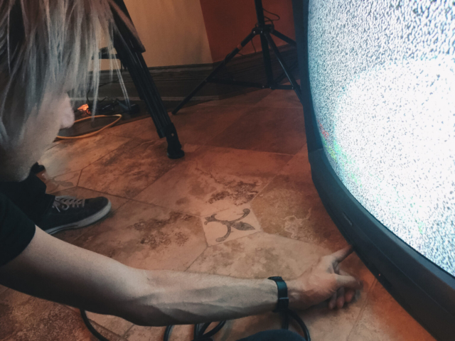 Man trying to adjust static settings on a old tube television.