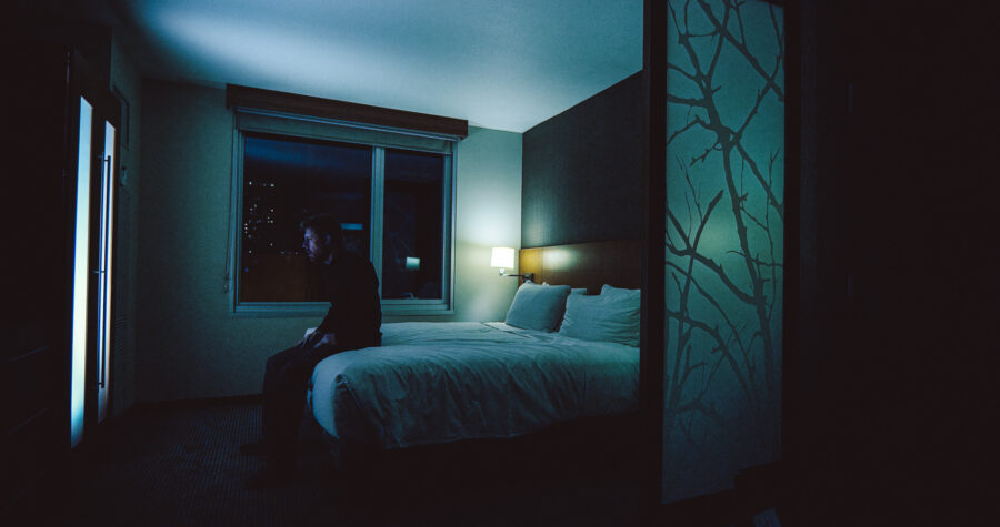 a man, robert felker, sits on the edge of a hotel room bed in a short film by jason kraynek shot on red epic cameras