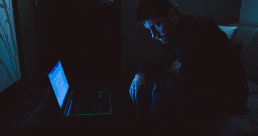 a man, robert felker, looks at a laptop in the dark in a short film by jason kraynek shot on red epic cameras