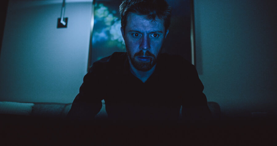 a man, robert felker, looks at a laptop in the dark in a short film by jason kraynek shot on red epic cameras