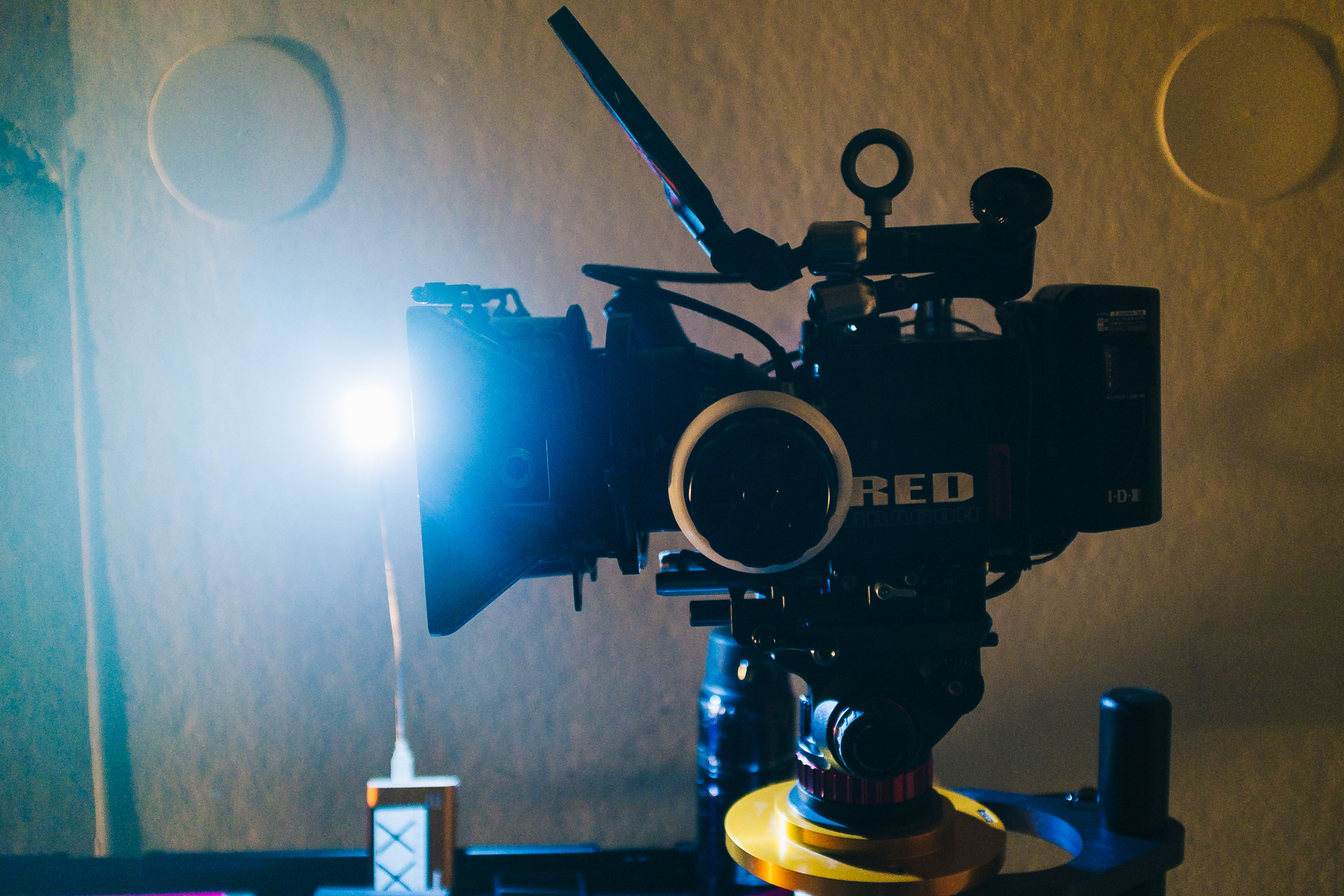 RED Dragon camera on tripod mount with light shining.
