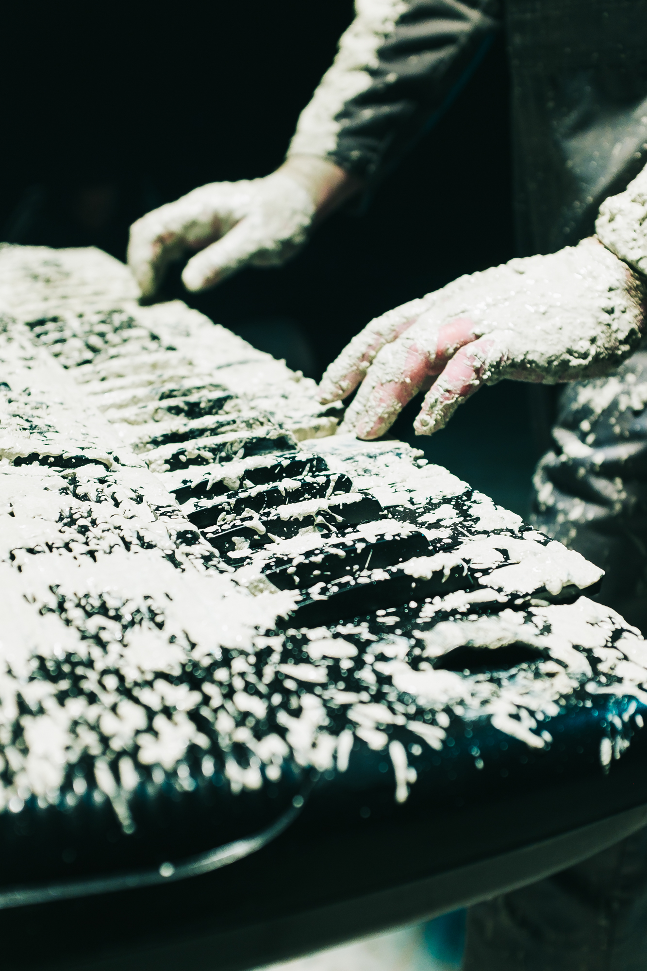 Mud covered keyboard with hands lit from above.